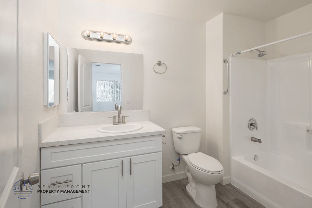 A white bathroom with a toilet, sink, and bathtub.